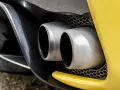 Podwójne końcówki wydechu sportowego samochodu. Wygląda, jakby ten diesel kopcił na czarno, ale to tylko odbicie.