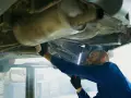 Mechanik bada podwozie Opla, szukając przyczyny błędu DTC P0420.