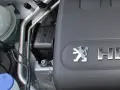 Elementy silnika, w tym poduszka silnika, gotowe do wymiany. Widoczny symbol Peugeot.