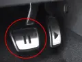 Metalowe pedały w samochodzie, jeden z symbolem "II" (auto hold) i drugi z trójkątem.