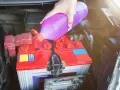Ręka wlewa płyn do akumulatora, dbając o jego prawidłowe działanie.