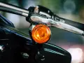 Pomarańczowy kierunkowskaz motocykla, gotowy do sygnalizowania skrętu.