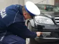 Policjant sprawdza, jakie światła do jazdy dziennej zamontowano w czarnym Mercedesie.