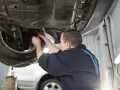 Mechanik wymienia płyn hamulcowy w samochodzie. Dowiedz się, ile kosztuje wymiana płynu hamulcowego.