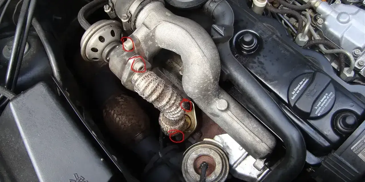 Silnik BMW z zaznaczonymi elementami układu recyrkulacji spalin, potencjalnie związanymi z błędem DTC P0401.