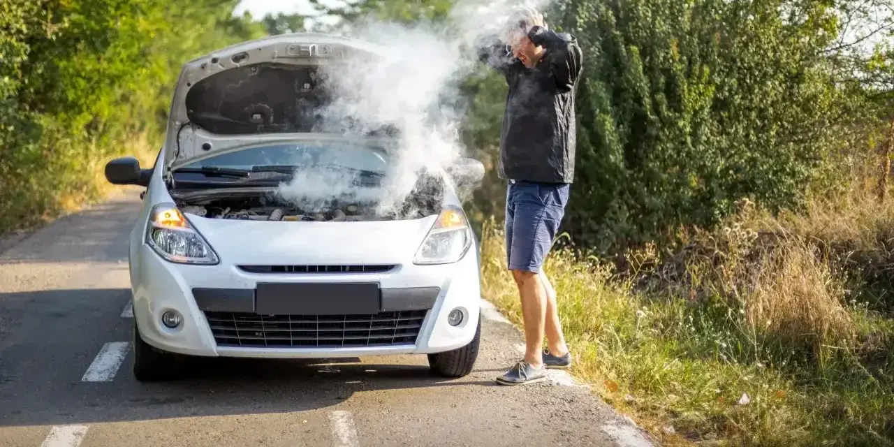 Rozbiegany diesel dymi spod maski. Zrezygnowany kierowca łapie się za głowę na poboczu.