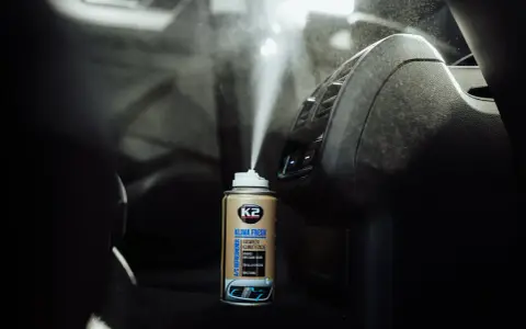 Pryskanie preparatem K2 Klima Fresh do dezynfekcji klimatyzacji samochodowej. Mgła rozpyla się w kierunku nawiewów.