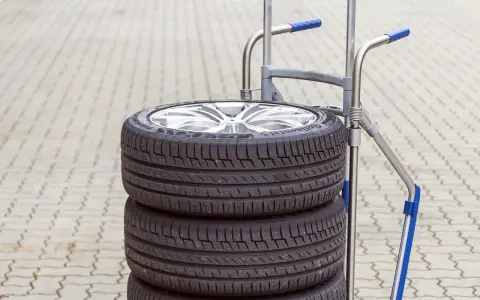 Stos czterech opon samochodowych na wózku. Zastanawiasz się, ile waży opona samochodowa?