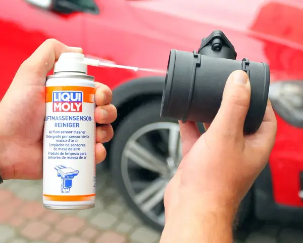 Czyszczenie przepływomierza: puszka preparatu Liqui Moly rozpyla płyn na element silnika.