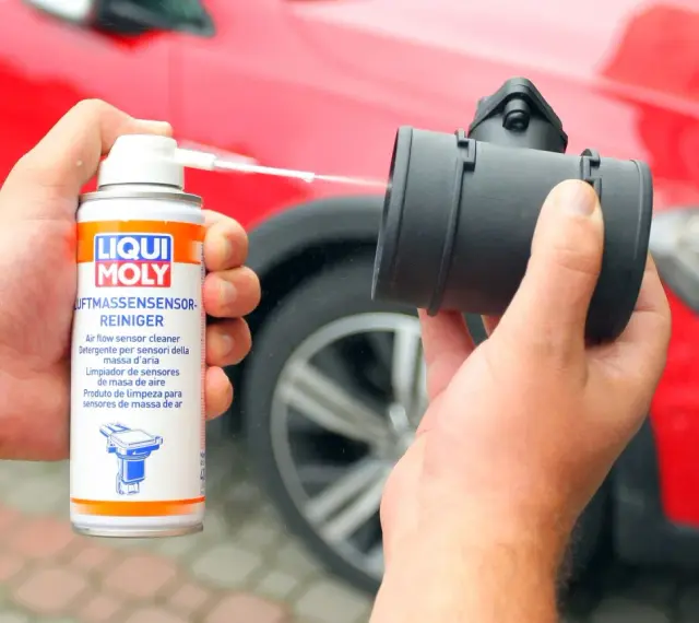 Czyszczenie przepływomierza: puszka preparatu Liqui Moly rozpyla płyn na element silnika.