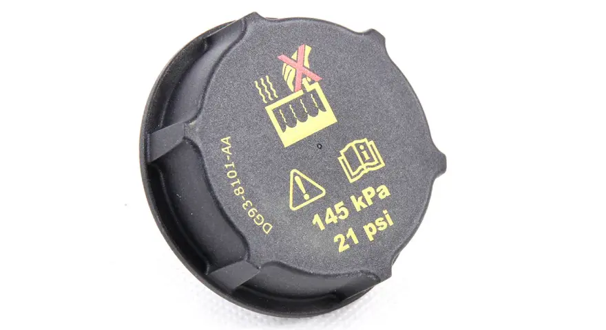 Czarne oznaczenie wlewu płynu do chłodnicy z symbolami ostrzegawczymi i informacją o ciśnieniu 145 kPa (21 psi).
