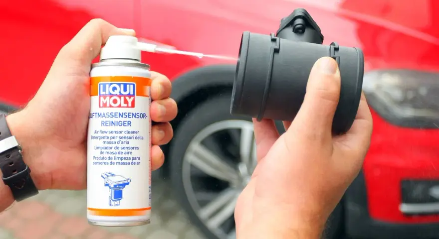 Czyszczenie przepływomierza: puszka preparatu Liqui Moly rozpyla płyn na element silnika.