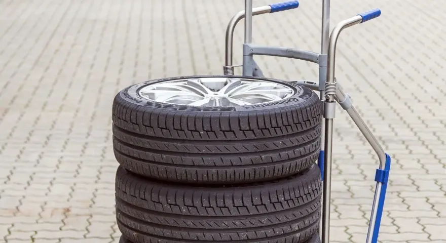 Stos czterech opon samochodowych na wózku. Zastanawiasz się, ile waży opona samochodowa?