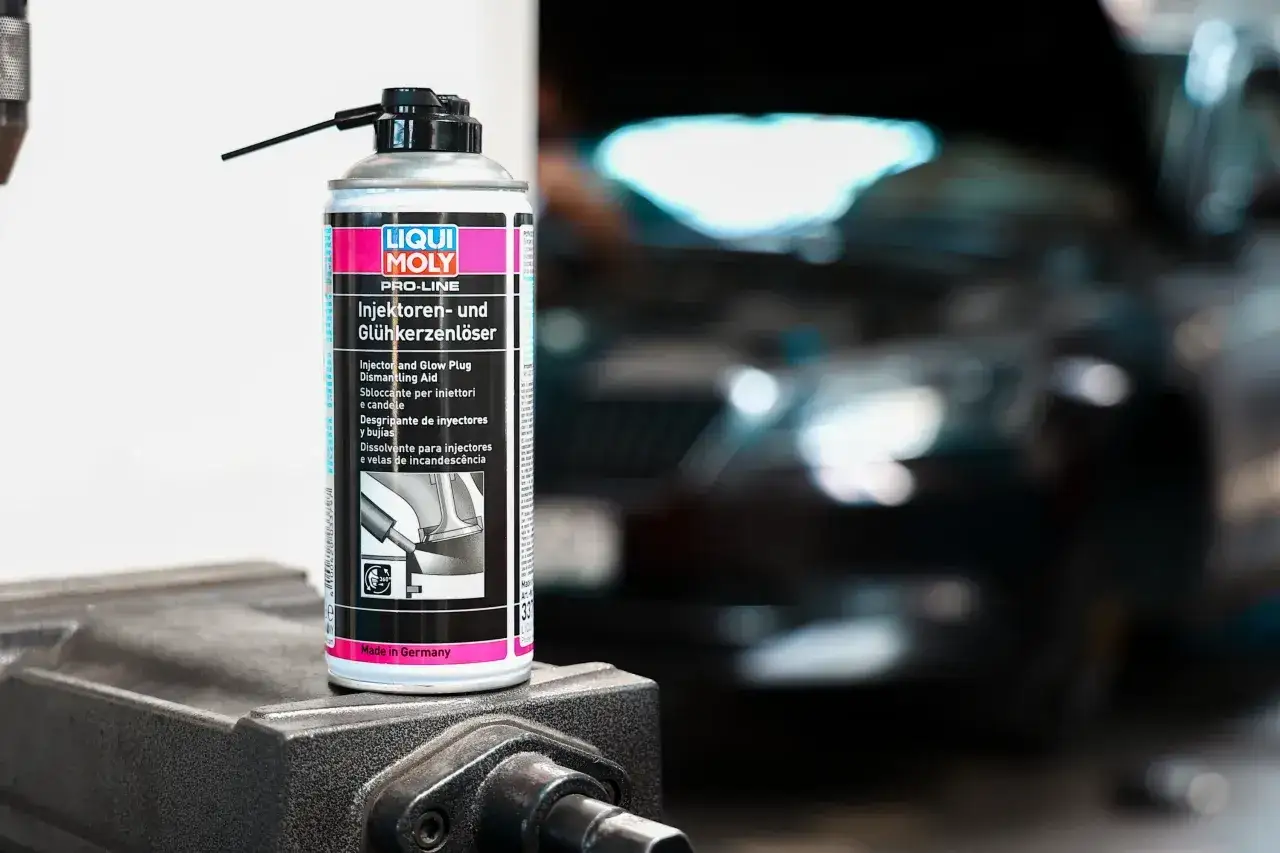 Puszka preparatu Liqui Moly do czyszczenia wtryskiwaczy benzynowych i świec żarowych, gotowa do użycia w warsztacie samochodowym.