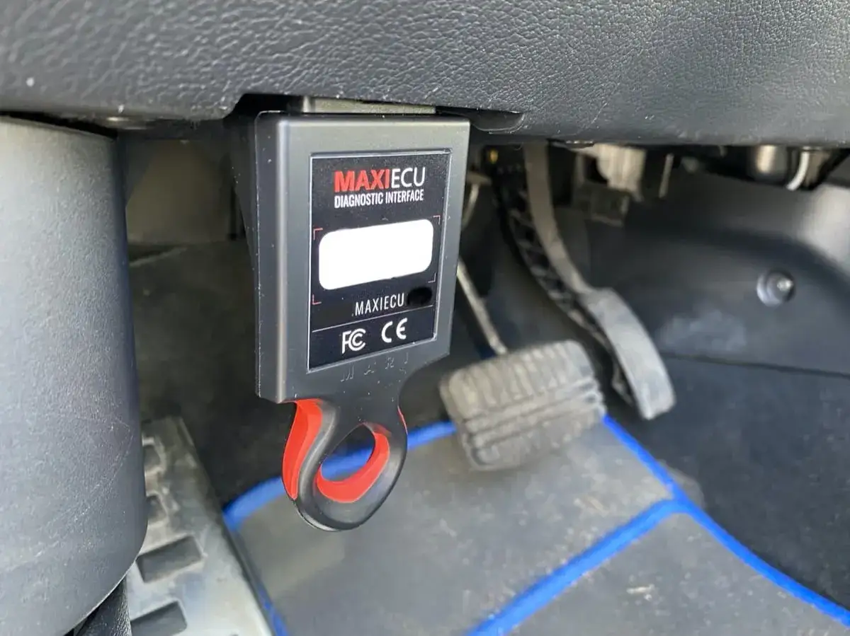 Interfejs diagnostyczny MaxiECU podłączony do gniazda OBD w Volkswagenie, gotowy do diagnozy błędów, np. DTC P0420.