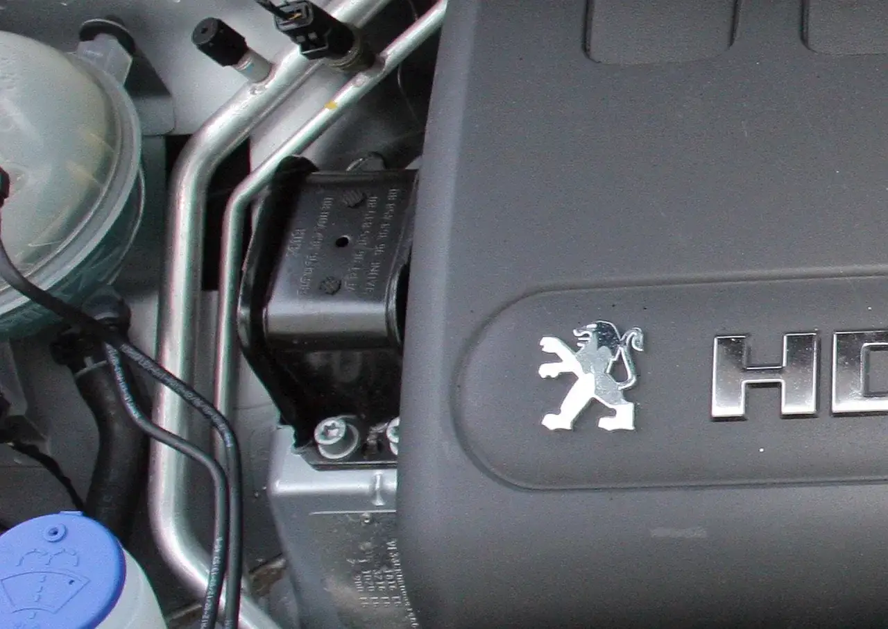 Element mocowania silnika, gotowy do wymiany poduszki silnika. Widoczny symbol Peugeot.